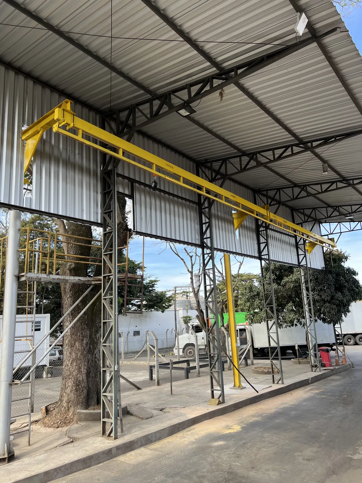 Linha de vida em trilho rígido amarelo instalada em galpão industrial